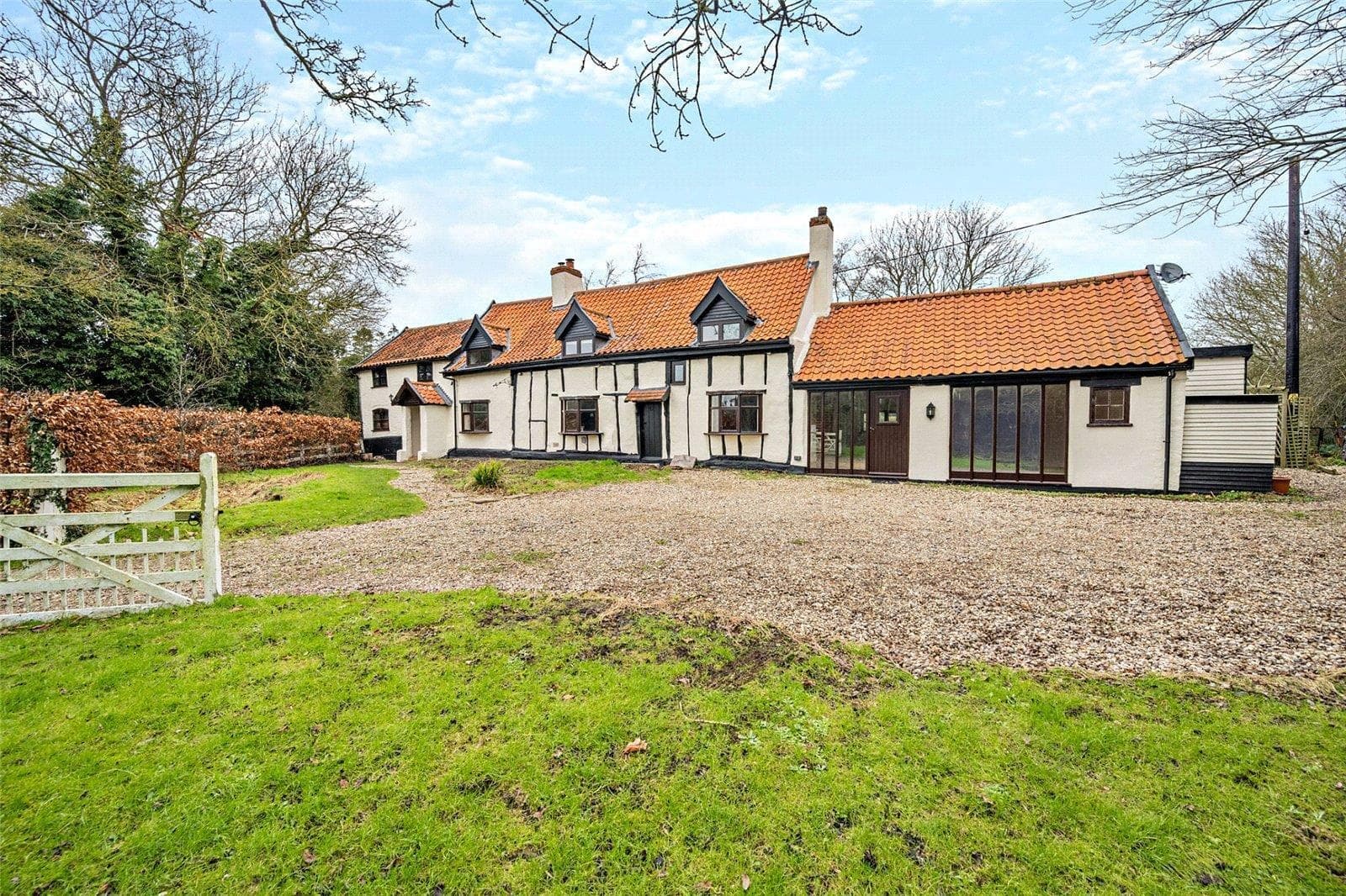 The Sawyers from Sawyer's Lane, a white timber-framed house with a pantiled roof behind a gravel courtyard and a five-bar gate